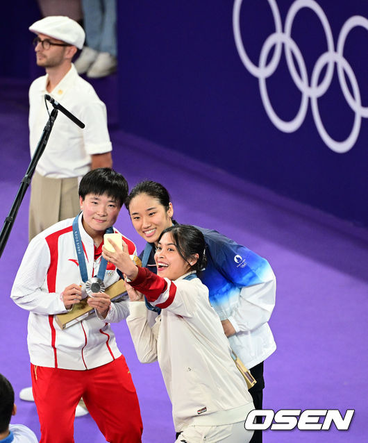 [OSEN=파리(프랑스), 최규한 기자] 5일(한국시간) '셔틀콕 여제' 안세영(22, 삼성생명)이 꿈에 그리던 올림픽 금메달을 목에 걸었다.세계 랭킹 1위 안세영은 5일 오후(이하 한국시간) 프랑스 파리 포르트 드 라샤펠 경기장에서 열린 2024 파리올림픽 배드민턴 여자 단식 결승전에서 랭킹 9위 허빙자오(중국)를 2-0으로 꺾고 금메달을 획득 했다.  금메달 한국 안세영(가운데)와 은메달 중국 허빙자오, 동메달 인도네시아 툰중이 시상대에서 기념촬영을 있다. 2024.08.05 / dreamer@osen.co.kr