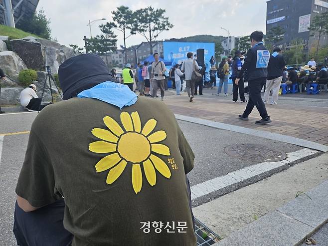 아리셀 화성참사 희생자 유가족이 지난 17일 경기 화성 모두누림센터 앞 ‘8·17 아리셀 희망버스’ 행사 현장에 앉아 있다. 박채연 기자