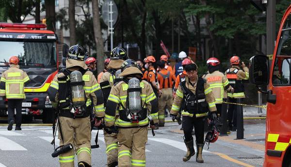 지난 6월 19일 서울 양천구 목동에 있는 23층짜리 아파트 지하 주차장에서 오전 8시께 화재가 발생해 소방당국이 9시간 넘게 진화 작업에 나선 가운데 소방관들이 건물로 향하고 있다. 연합뉴스
