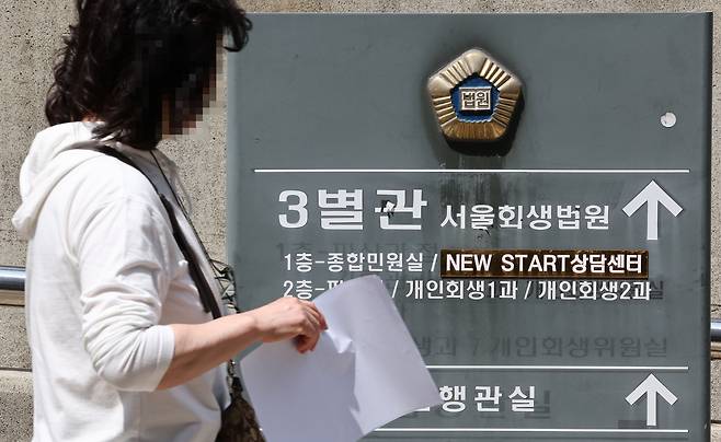 A pedestrian walks past a directory board at the Seoul Bankruptcy Court in southern Seoul on May 17. [YONHAP]