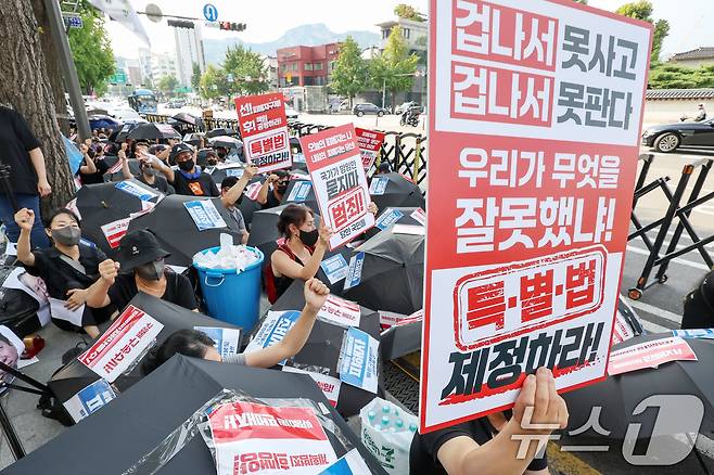 '티메프 사태' 피해자들이 18일 오후 서울 종로구 사직로 일대에서 열린 검은우산 집회에서 구호를 외치고 있다. 이날 참가자들은 정부에 실효성 있는 구제방안 마련과 특별법 제정을 촉구했다. 2024.8.18/뉴스1 ⓒ News1 민경석 기자