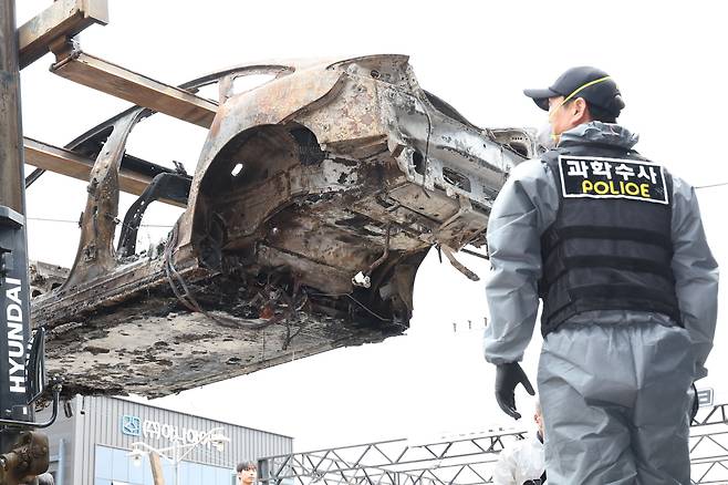 지난 8일 오전 인천 서구의 한 정비소에서 청라 아파트 지하주차장에서 발생한 화재로 전소된 전기차가 2차 합동감식을 받기 위해 지게차에 실려 정비소 내부로 향하고 있다. /뉴스1