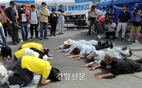 2008년 9월 4일 지리산 노고단에서 열린 오체투지 순례 출발행사에서 문규현 신부와 수경 스님이 오체투지로 땅바닥에 엎드려 손을 맞잡고 있다. 경향신문 자료사진