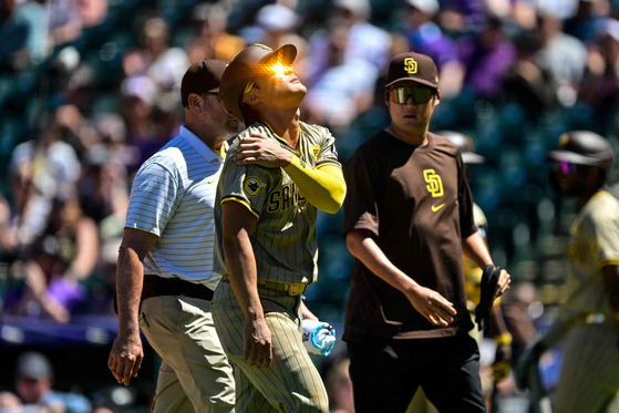 Kim Ha-seong of the San Diego Padres comes out of the game with an apparent shoulder injury after sliding to avoid a pickoff attempt at first base in the third inning against the Colorado Rockies at Coors Field in Denver, Colorado on Sunday. [AFP/YONHAP]