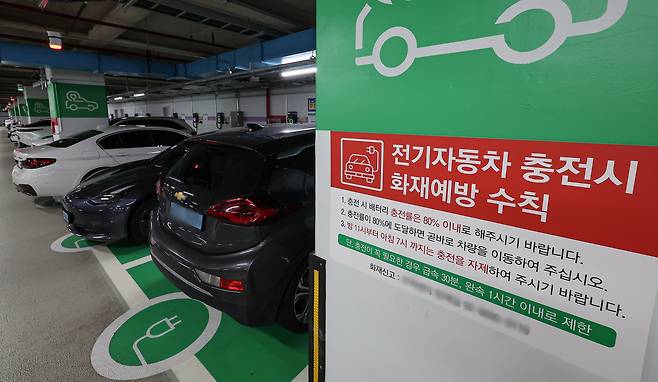 A notice encourages people to stop charging their EVs when they reach 80 percent in an underground parking lot in downtown Seoul on Aug. 9. [NEWS1]