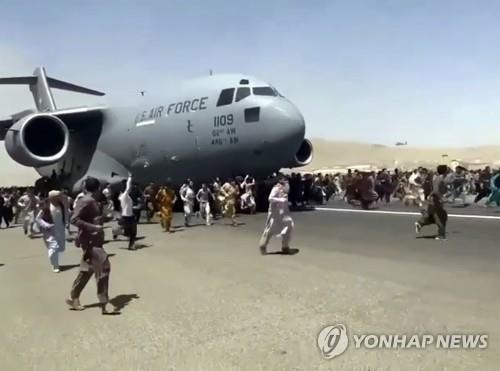 철수하는 미군 항공기에 탑승하지 못한 채 활주로를 함께 달리는 아프가니스탄인들 [AP 연합뉴스 자료사진. 재판매 및 DB 금지]