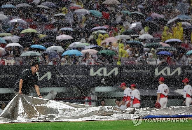 광주 롯데-KIA전 소나기에 경기중단 (광주=연합뉴스) 조남수 기자 = 20일 광주기아챔피언스필드에서 열린 프로야구 롯데 자이언츠와 KIA 타이거즈의 경기. 롯데가 1-3으로 뒤진 4회초 공격 때 갑자기 쏟아지는 뇌우에 경기가 중단돼 경기장 관계자들이 방수포를 설치하고 있다. 2024.8.20 iso64@yna.co.kr