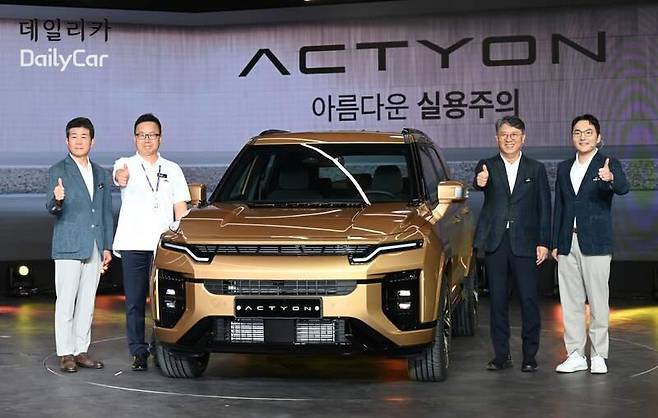 KG모빌리티가 선보인 도심형 SUV 액티언 앞에서 곽재선 회장과 이하 임직원들이 사진을 촬영하고 있다.