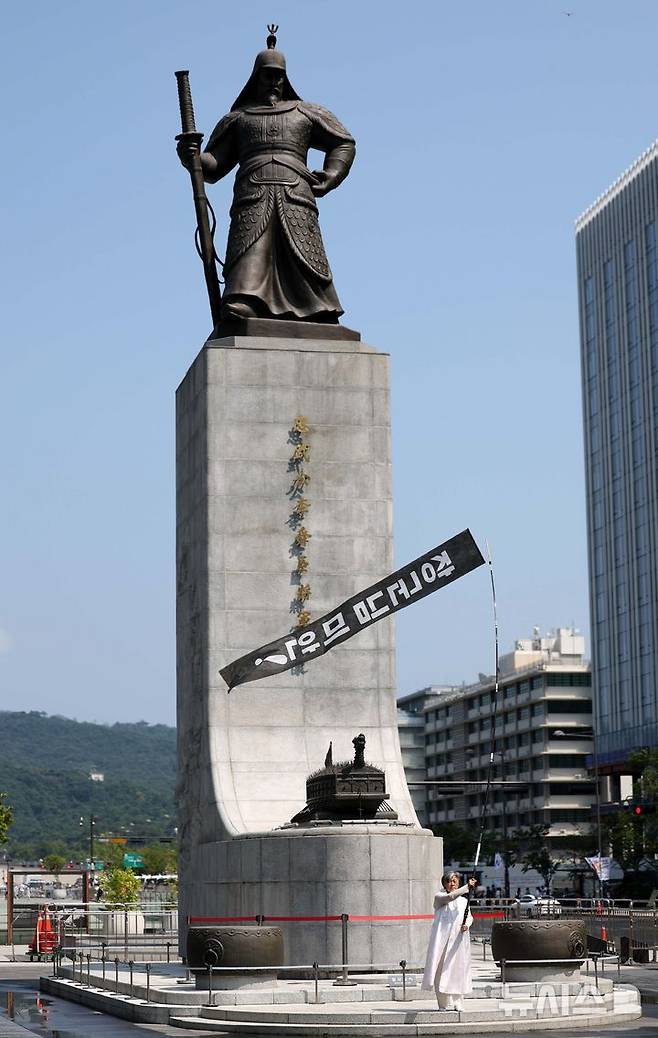 [서울=뉴시스] 김선웅 기자 = 항일여성독립운동기념사업회 이사장 양혜경 작가가 광복절인 15일 서울 종로구 광화문광장 이순신장군 동상 앞에서 '장군님 미안'이라고 써진 만장을 들고 윤석열 정부를 비판하는 항일 퍼포먼스를 펼치고 있다. 2024.08.15. mangusta@newsis.com