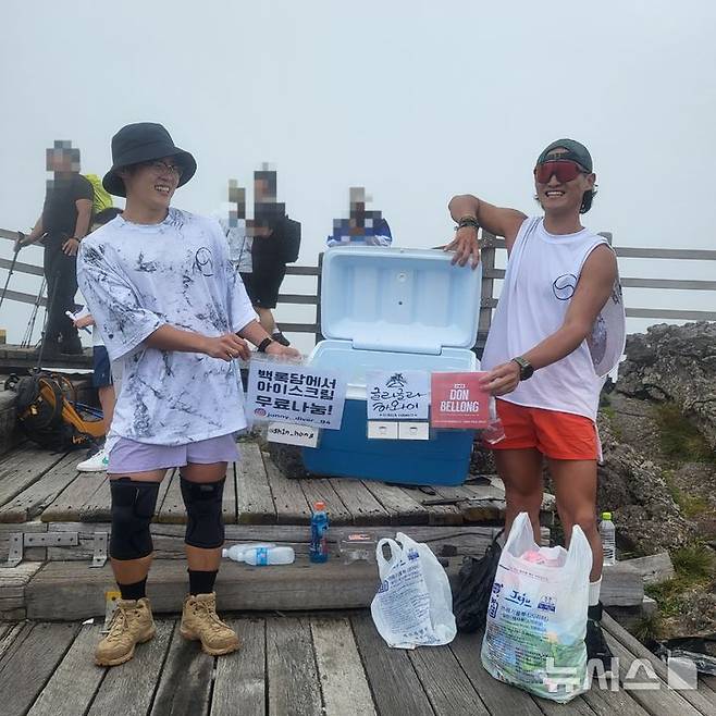 [제주=뉴시스] 광복절인 15일 오후 제주 한라산 정상에서 (왼쪽)조신홍씨와 곽용준씨가 아이스크림 나눔 활동을 하고 있다. (사진=독자 제공) 2024.08.15. photo@newsis.com