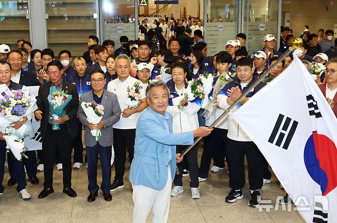 [인천공항=뉴시스] 황준선 기자 = 이기흥 대한체육회장이 13일 오후 2024 파리올림픽을 마친 뒤 인천국제공항을 통해 귀국하며 태극기를 휘두르고 있다. 2024.08.13. hwang@newsis.com