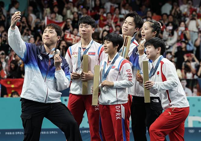 대한민국 탁구 대표팀 신유빈, 임종훈 선수가 30일(한국시간) 프랑스 파리 사우스 파리 아레나4에서 열린 2024 파리올림픽 탁구 혼합 복식 시상식에서 금메달을 획득한 중국 왕추친, 쑨잉사와 은메달을 획득한 북한 리정식, 김금용과 함께 기념촬영을 하고 있다. 2024.7.30. 뉴스1