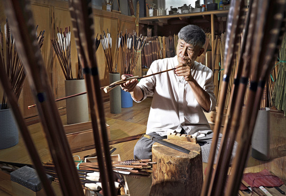 Yoo Se-hyun, an intangible cultural asset for his skills in making traditional arrows, checks on the shaft to see whether the shaft is twisted or not at his studio located in Young Jip Bows & Arrows Museum in Paju, Gyeonggi. [PARK SANG-MOON]