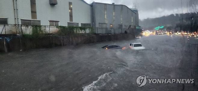 최근 울산에 내린 폭우로 도로가 침수돼 차량이 물에 잠긴 모습. [사진 출처 = 연합뉴스]