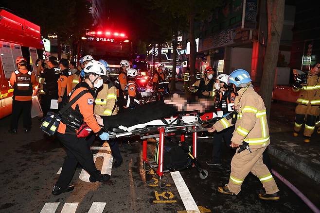 22일 저녁 경기도 부천시 한 호텔의 화재 현장에서 소방대원들이 환자를 이송하고 있다. 이 불로 7명이 숨졌고 12명이 다쳤다. 연합뉴스