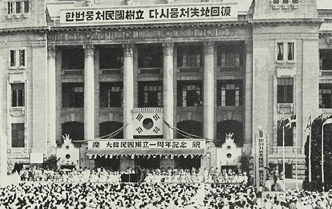 1949년 8월 15일 서울 중앙청 광장에서 열린 ‘대한민국 독립 1주년 기념식’ 모습. 중앙청 건물 윗부분에 내걸린 대형 플래카드에 적힌 문구 ‘한번 뭉처 민국 수립, 다시 뭉처 실지 회복’은 독립 1주년을 기념하여 국민에게 공모한 것이었다./조선일보 DB