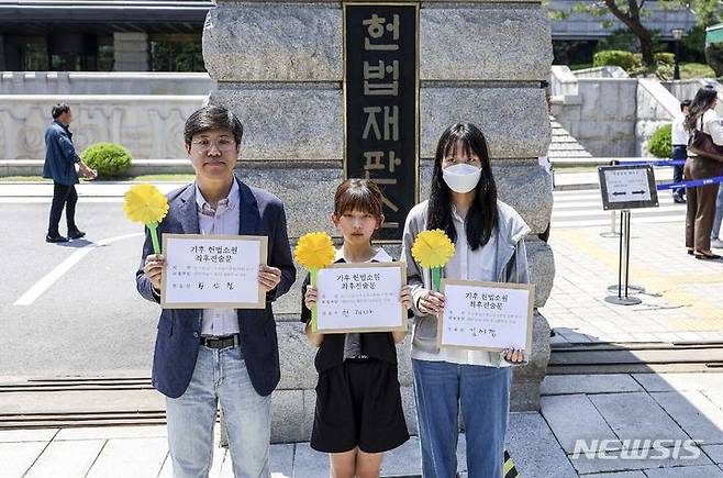 [서울=뉴시스] 정병혁 기자 =  청소년·시민·아기 기후소송 대표자들이 21일 서울 종로구 헌법재판소 앞에서 열린 기후 헌법소원 마지막 공개변론에 앞서 기후 헌법소원 최후진술문을 들고 있다. 2024.05.21. jhope@newsis.com