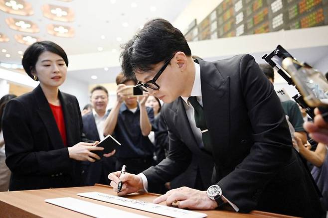 한동훈 국민의힘 대표가 27일 서울 여의도 한국거래소를 방문해 '국내 자본시장과 개인 투자자 보호를 위한 금융투자소득세 폐지 자본시장 관계자와의 간담회'에 앞서 방명록 작성을 하고 있다. ⓒ뉴시스