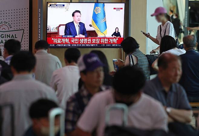 29일 오전 서울 용산구 서울역 대합실에서 시민들이 윤석열 대통령의 국정브리핑 및 기자회견 방송을 시청하고 있다. 연합뉴스