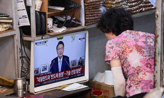 29일 오전 서울시내 한 전통시장에서 상인이 윤석열 대통령의 국정브리핑 및 기자회견 중계방송을 지켜보고 있다. 연합뉴스