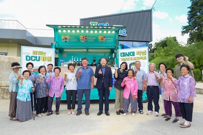 이근용 대구사이버대 총장이 29일 경북 예천군 개포면 풍정리를 방문해 마을 주민들께 음료를 제공하고 단체사진을 촬영하고 있다.