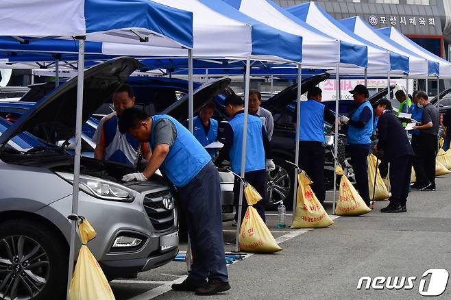 경북자동차전문정비조합 포항시지회와 검사정비사업조합 회원들이 20일 포항시 남구 포항종합운동장 앞에서 추석맞이 자동차 무상 점검 서비스를 실시하고 있다. 2023.9.20/뉴스1 ⓒ News1 최창호 기자