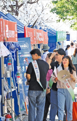 30일 강원 양구군 서천 레포츠공원에서 개막한 ‘2024 국토정중앙 청춘양구 배꼽축제’에서 ‘바가지 요금 근절’ 띠를 두른 군청 관계자들이 행사장을 살펴보고 있다.  /연합뉴스