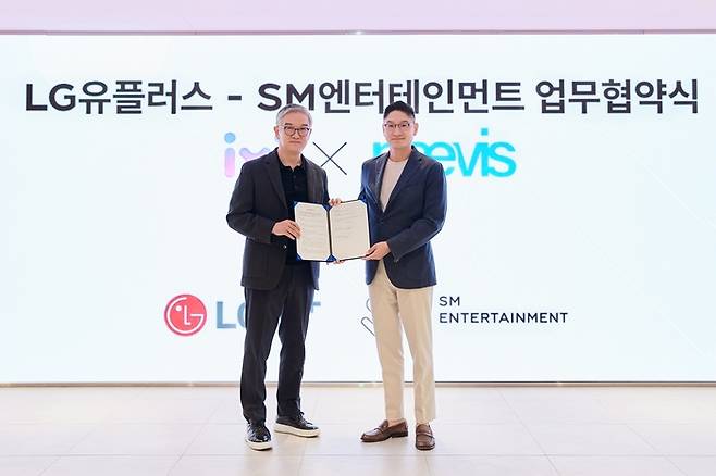 정수헌 LG유플러스 컨슈머부문장(왼쪽)과 탁영준 SM엔터테인먼트 대표가 지난달 29일 서울 성수동 SM 사옥에서 업무협약식을 진행하고 기념사진을 촬영하고 있다.