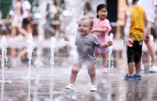 Children are playing in a fountain at Gwanghwamun Plaza in Seoul on Aug. 23. (Yonhap)