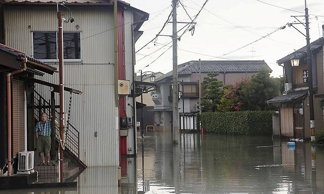 지난달 31일 일본 중부 기후현 오가키의 주택가에서 한 노인이 태풍 산산으로 강이 범람해 물에 잠긴 도로를 보고 있다. 오가키=교도연합뉴스