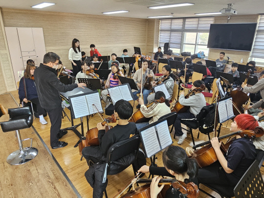 은산초 학생들이 방과후늘봄교실에서 오케스트라 합주를 하며 지휘자의 이야기를 듣고 있다. 충남교육청 제공.