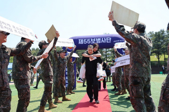 지난 5월15일 55사단(경기 용인)에서 병무청 주관으로 열린 현역병 입영문화제에서 입영대상자가 부모님을 업고 ‘감사&사랑’의 길을 지나고 있다. 병무청 제공