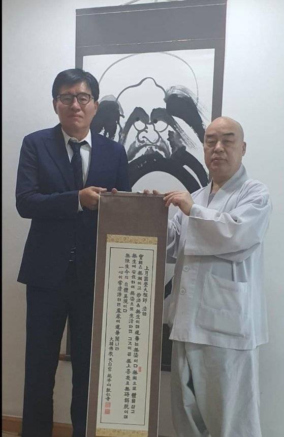 배상윤 KH그룹 회장이 지난해 당시 천태종 총무원장이던 무원 스님과 기념 촬영을 하고 있다. 배 회장과 무원스님이 들고 있는 두루마리에는 천태종 초대 종정인 상월원각대조사의 법어가 적혀 있다. 늘 청정한 마음을 지녀야 한다는 가르침을 담고 있다. 사진 독자 제공