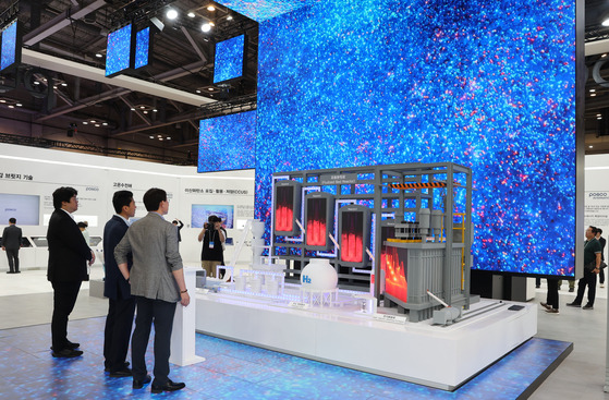 Visitors to the Posco booth at the 2024 World Climate Industry Expo (WCE) look at a model of hydrogen reduction steelmaking technology on Wednesday. [YONHAP]