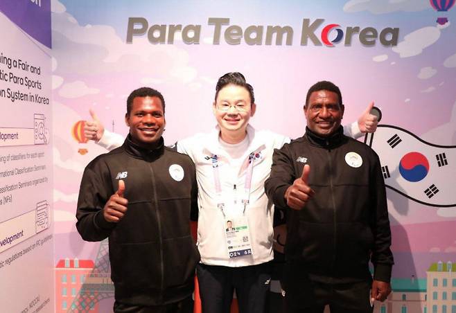 Ken Kahu (left) poses for a photo with Bae Dong-hyun (center), chairman of the BDH Foundation, during his visit to Para Team Korea House in Paris on September 4. Courtesy of the the Korean Paralympic Committee