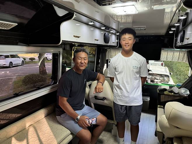 황건(오른쪽)과 아버지 황성용 씨가 숙식을 해결하고 있는 버스 내에서 포즈를 취하고 있다. 임정우 기자