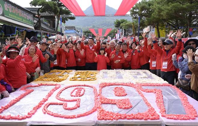 [순창=뉴시스] 김종효 기자 = 14일 ‘제18회 순창장류축제’ 2일차, 새롭게 선보인 축제 주요 프로그램 ‘300m 가래떡 꼬기’가 열띤 성원 속에 펼쳐졌다. 행사 후 나눔떡으로 잘려 모양을 낸 가래떡판 주위로 참여자들이 기념사진을 찍고 있다. (사진 = 순창군 제공) 2023.10.14. photo@newsis.com  *재판매 및 DB 금지