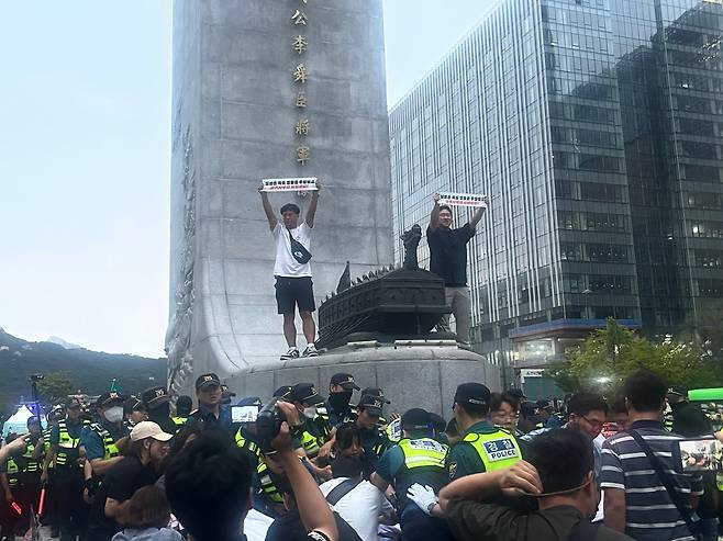 전국민주노동조합총연맹이 6일 오후 서울 종로구 광화문광장 내에서 집회를 벌이던 중 관계자 2명이 이순신 동상 위에 올라간 모습. /고유찬 기자