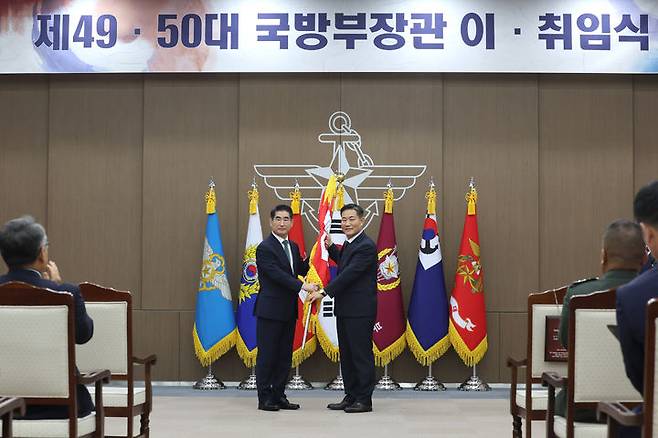 [서울=뉴시스] 6일 오후 서울 용산 국방부 청사에서 열린 국방장관 이·취임식에서 신원식 국방부 장관(우측)이 김용현 신임 국방부장관에게 국방부기를 이양하고 있다. *재판매 및 DB 금지