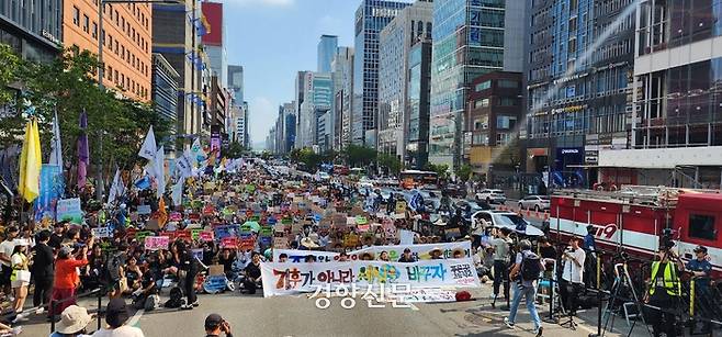 7일 서울 강남에서 열린 907기후정의행진 참가자들이 행진에 앞서 본집회에 참여해 앉아있다. 김기범 기자