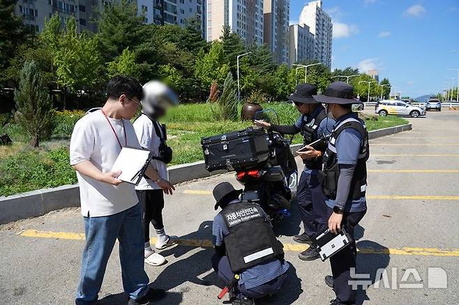 [서울=뉴시스] 한국교통안전공단은 8월 28일 대전 큰마을 네거리에서 지자체 공무원과 함께 이륜차를 점검했다. (사진 = 한국교통안전공단 제공)