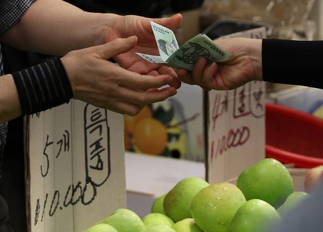 지난달 26일 서울 한 시장에서 시민이 과일값을 건네고 있다. 사진=연합뉴스&nbsp;
