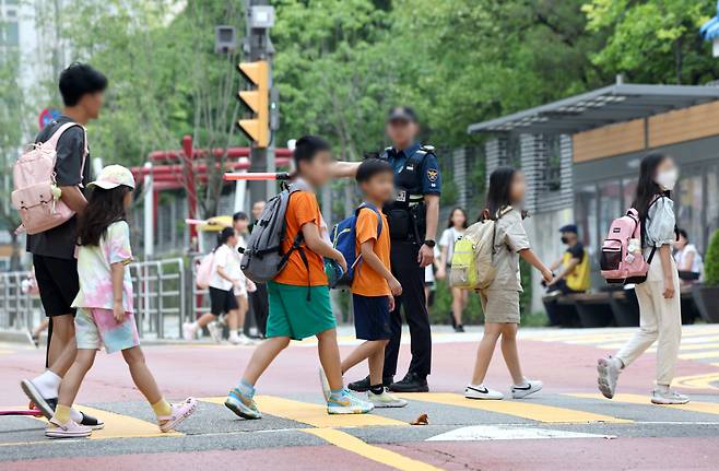 Students cross the road in front of Hyehwa Elementary School in Jongno-gu, central Seoul, Aug. 26. (Yonhap)