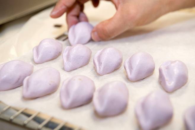 A guest makes songpyeon, a type of Korean rice cake, at a Buddhist temple ahead of the Chuseok holiday. [CULTURAL CORPS OF KOREAN BUDDHISM]