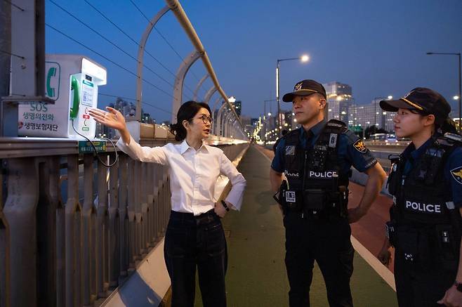 김건희 여사가 10일 ‘세계 자살 예방의 날’을 맞아 서울 마포대교에서 생명의 전화에 대한 설명을 청취하고 있다. 대통령실 제공