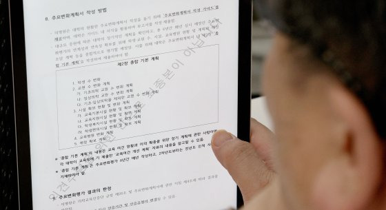 지난 7월 30일 서울 중구 은행회관에서 열린 '의대 입학정원 증원에 따른 주요변화평가 계획(안) 설명회'에 참석한 의과대학 관계자가 주요변화계획서 작성에 관한 안내문을 살펴보고 있다. 뉴스1