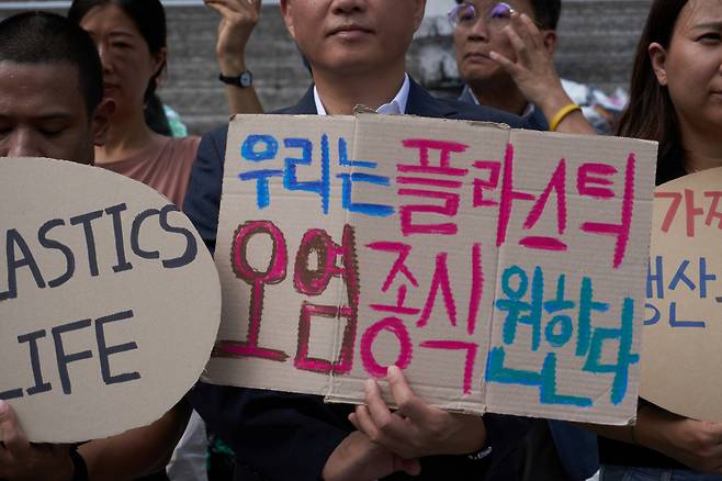 11일 오전 서울 종로구 세종문화회관에서 '플뿌리연대'가 정부의 강력한 플라스틱 규제 협약 참여와 국제협약 도출을 요구하는 퍼포먼스를 하고 있다. [플뿌리연대 제공]