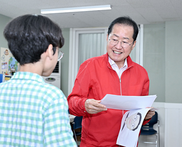 홍준표 대구시장이 애생보육원아들이그린 그림을 보며 격려하고 있다. [사진=대구시]