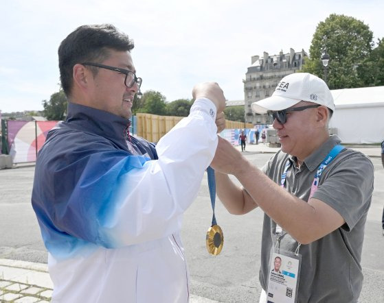 김우진이 지난 4일(현지시간) 프랑스 파리 앵발리드에서 열린 2024파리올림픽 양궁 남자 개인 결승에서 금메달을 차지한 후 정의선 대한양궁협회 회장에게 금메달을 걸어주고 있다. 올림픽사진공동취재단