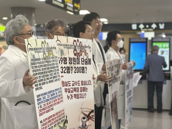 The emergency committee of medical professors at Kangwon National University and Kangwon National University Hospital hold picket signs to protest the government's expansion plan at the hospital's lobby on September 4. (Yonhap)